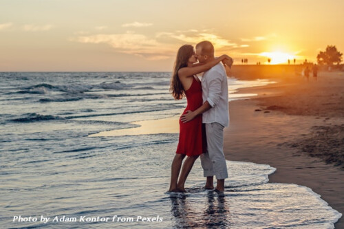 couple on beach abou to kiss with sunset in background