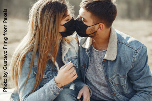 couple wearing masks touching faces
