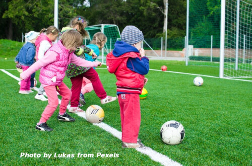 kids playing with ball on soccer field