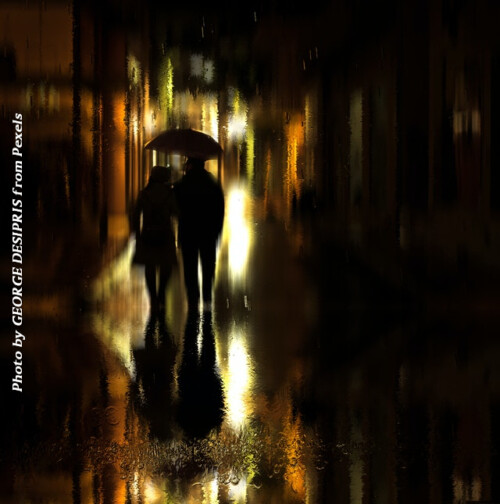 man and woman walking at night in the rain