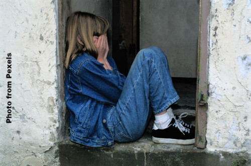 crying girl sitting in doorway