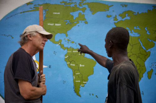 two men looking at world map