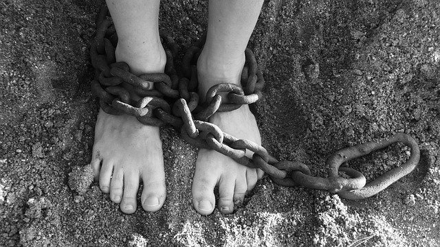 chained anles feet on sand