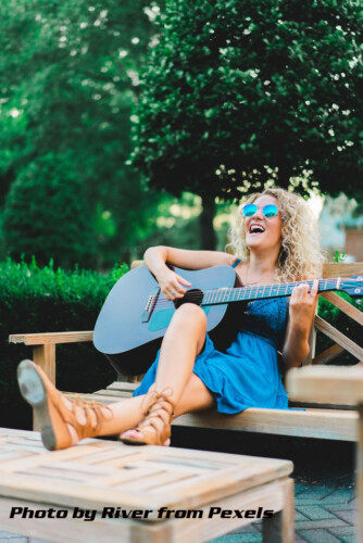 woman singing and playing guitar