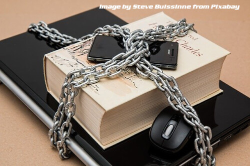 laptop, book and cel phone wrapped in chains