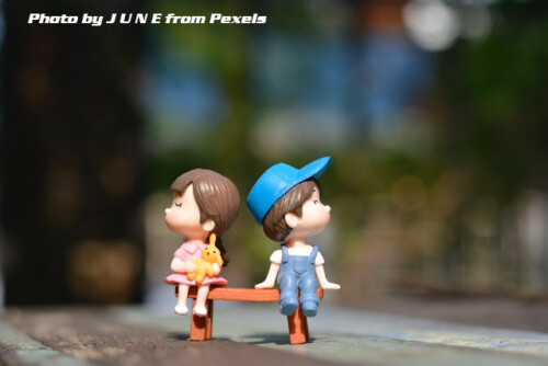 boy and girl dolls siting on bench