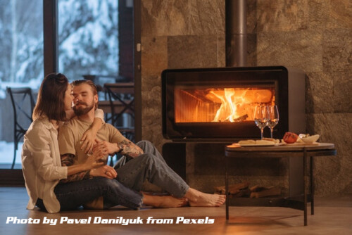 a couple sitting on floor by fireplace