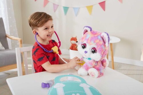 young boy playing doctor with cat doll