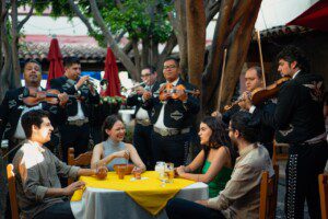 people at table with mariachi band